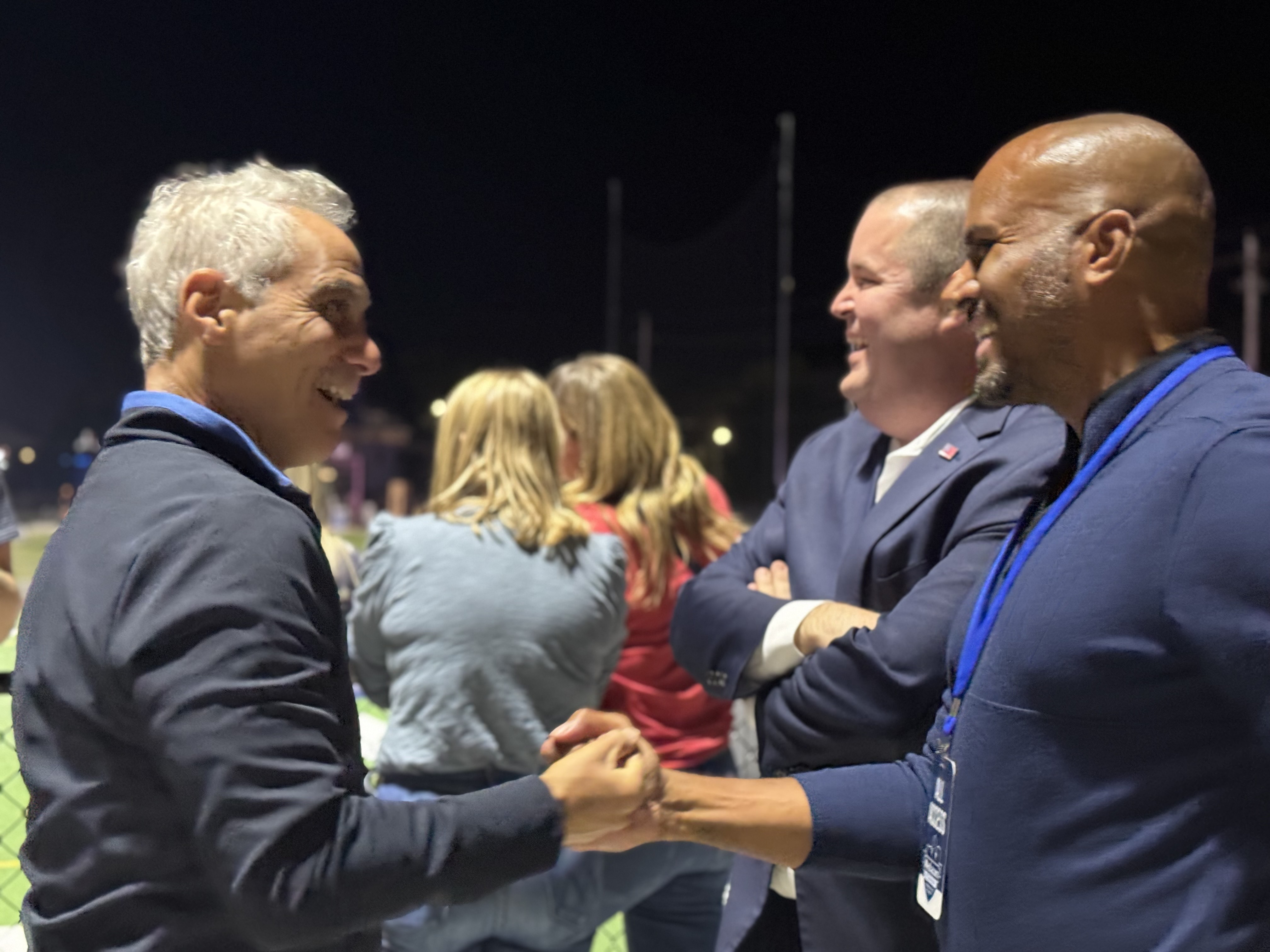 Rahm Emanuel fist bumps Iowa state Sen. Izaah Knox during a high school football game in Des Moines, on Friday, Sept. 26, 2025.